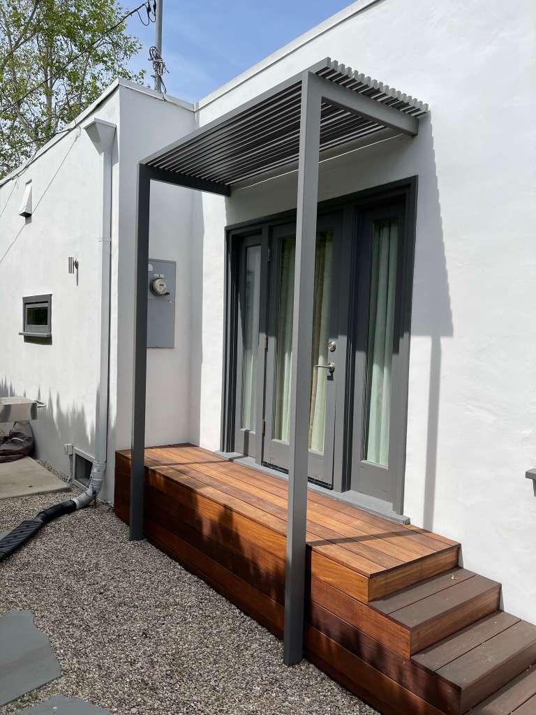 Residential outdoor deck stair area with shade structure and finished fencing details